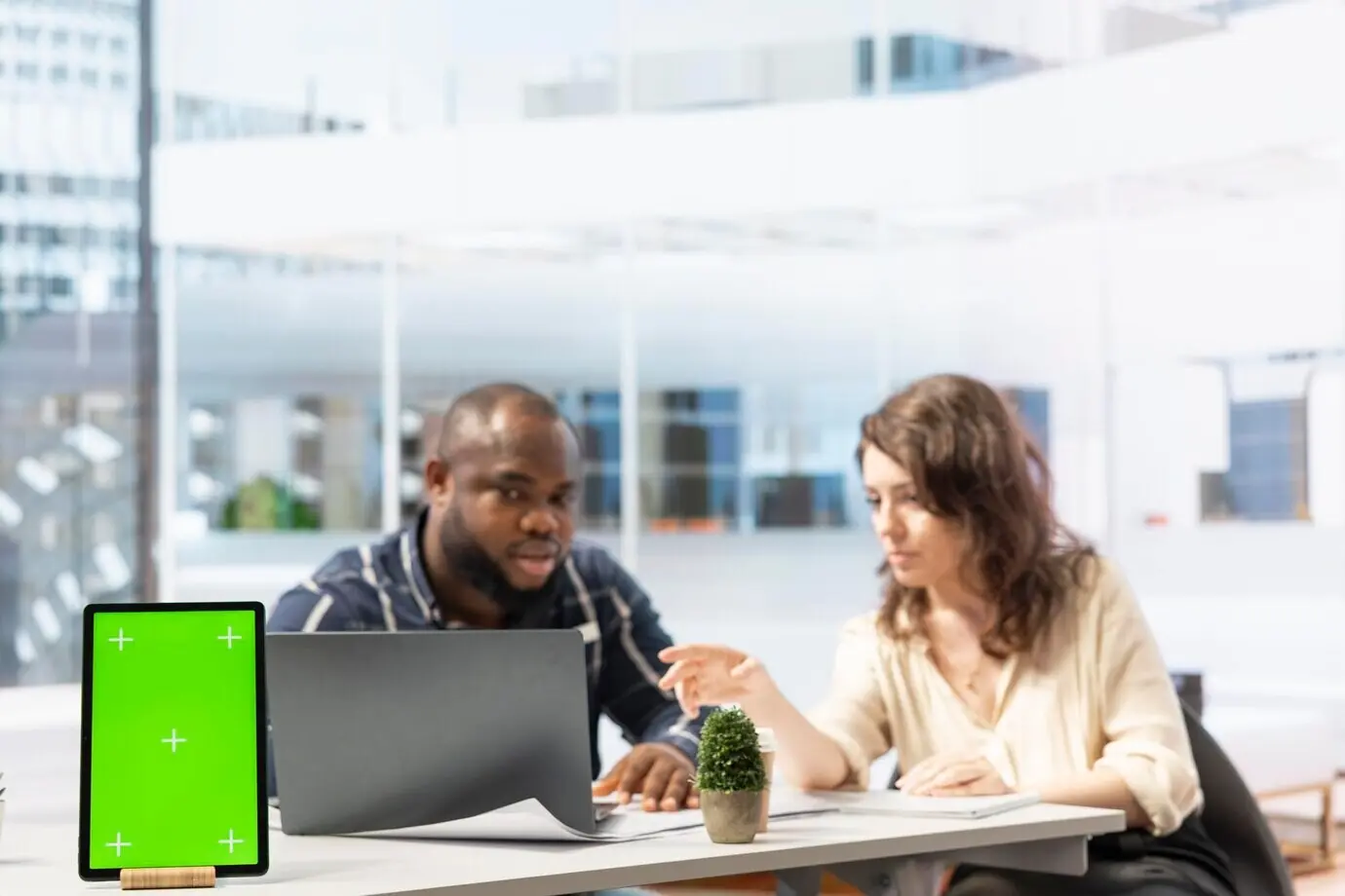 Предприниматель рассматривает чертежи вместе с агентом по недвижимости рядом с изолированным дисплеем